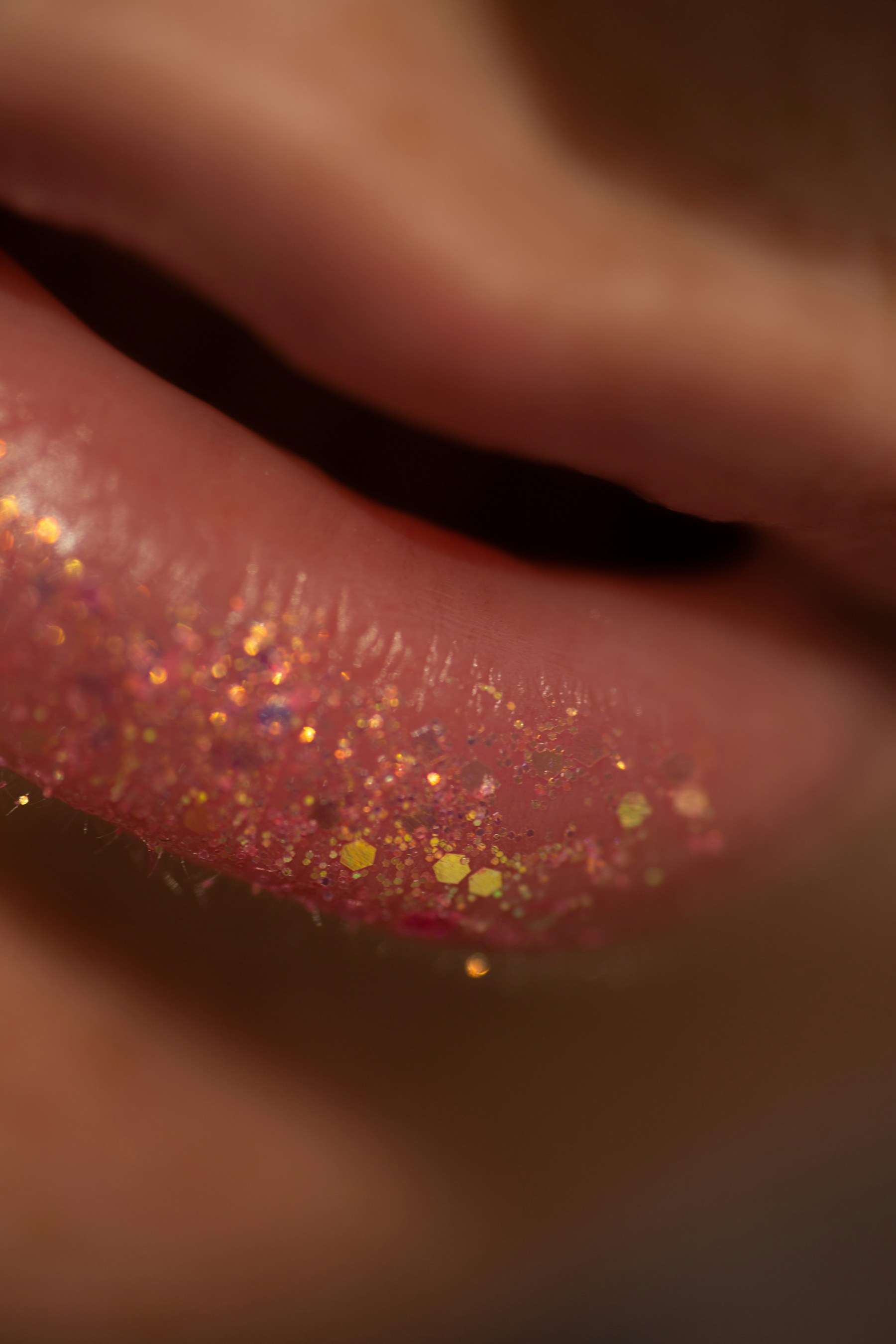 A close-up of lips finished with sparkling pink glitter makeup